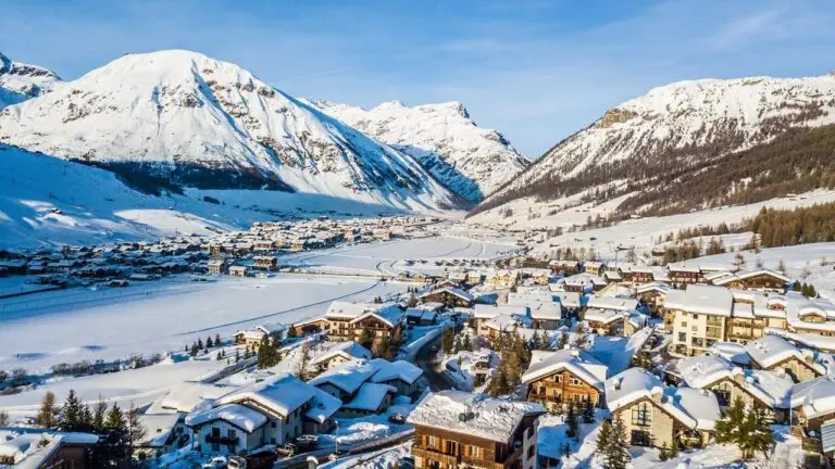 Elevated view of Livigno town spread along its snow-covered valley floor with mountains on both sides